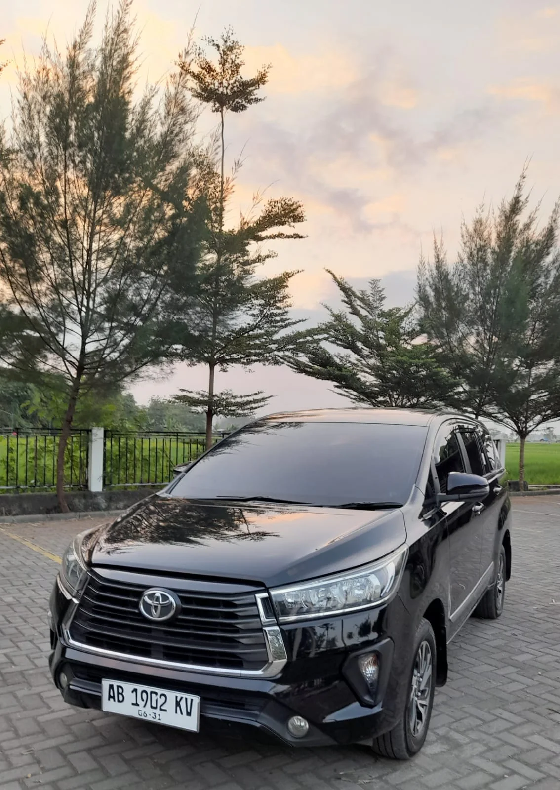 Toyota Innova Reborn FC hitam tampak depan tiga perempat